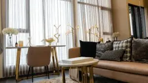 Interior of light living room with brown, grey sofas, coffee table and large window, modern